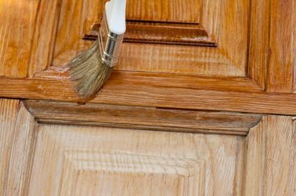 Applying a traditional oil base wood stain with a white bristle brush.