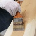 Brushing varnish on a wood plank.