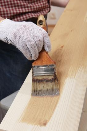 Brushing varnish on a wood plank.