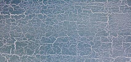 Crackled paint finish. Light background with metallic dark cracked paint.