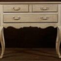 An old creamy white dresser with brown glaze.