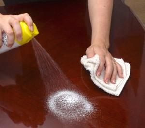 Polishing a table top with aerosol wood polish.