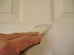 Brushing paint on door rail.