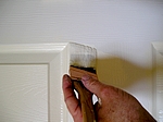 Brushing paint on door style.