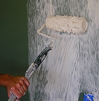 Using a paint roller to apply drywall mud for the stomp texture.