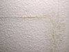 A stress crack in a textured ceiling.