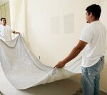 Laying down a drop cloth to protect the floor during painting.