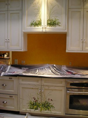 Beautifully painted and antiqued kitchen cabinets.