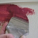 Cutting-in wall to a ceiling using red paint.