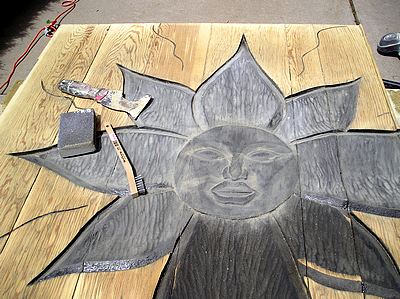 Hand sanding the carved wood areas.