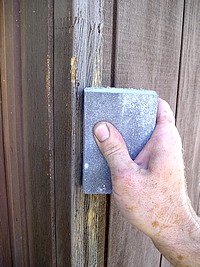 Hand sanding exterior wood door frame.