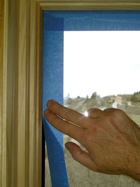 Applying blue tape to glass.