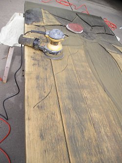 Sanding off the old finish from a solid wood front door.