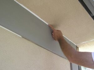 Smoothing caulking with a finger when applied to exterior wood trim.