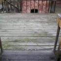 A very old worn wood deck in desperate need of refinishing.