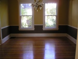 Dining room with yellow and brown paint colors separated with chair rail. 