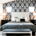 A stylish bedroom with a wallpapered wall as an accent.