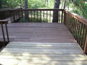 An old wood deck cleaned, sanded and having deck stain applied.