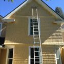 Long extension ladder extended up to a tall gable.