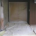 A homes entry fully masked with drop cloths and plastic film.