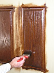 Carefully applying gel stain to the raised panels of a fiberglass door. Making sure to feather the gel stain into previously stained areas. 