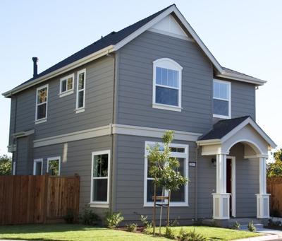 A freshly painted home using gray for the siding and white for the trim.