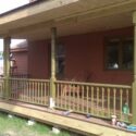 A covered front porch with painted columns and handrail.