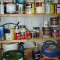 A storage closet full of leftover paint cans.