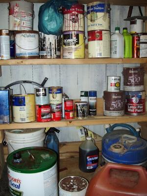 A storage closet full of leftover paint cans.