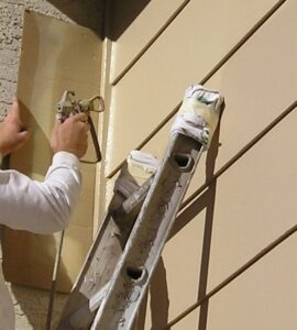 Spraying paint on a ladder and using a spray shield.