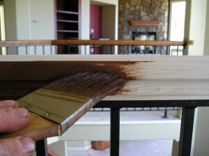 Applying a gel stain to oak wood trim.