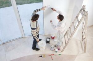 A house painter touching up a wall.