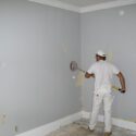 Sanding the wall after removing the wallpaper.