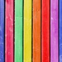 A wooden picket fence painted in various bright colors.