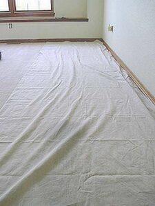 Butyl backed drop cloth in use while preparing a room for painting.