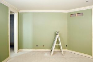 A room freshly painted with a green color and ready for flooring.