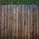 Old fence stained with dark wood stain.